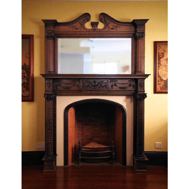 Victorian tiger oak fireplace with ornate carved details and mirror
